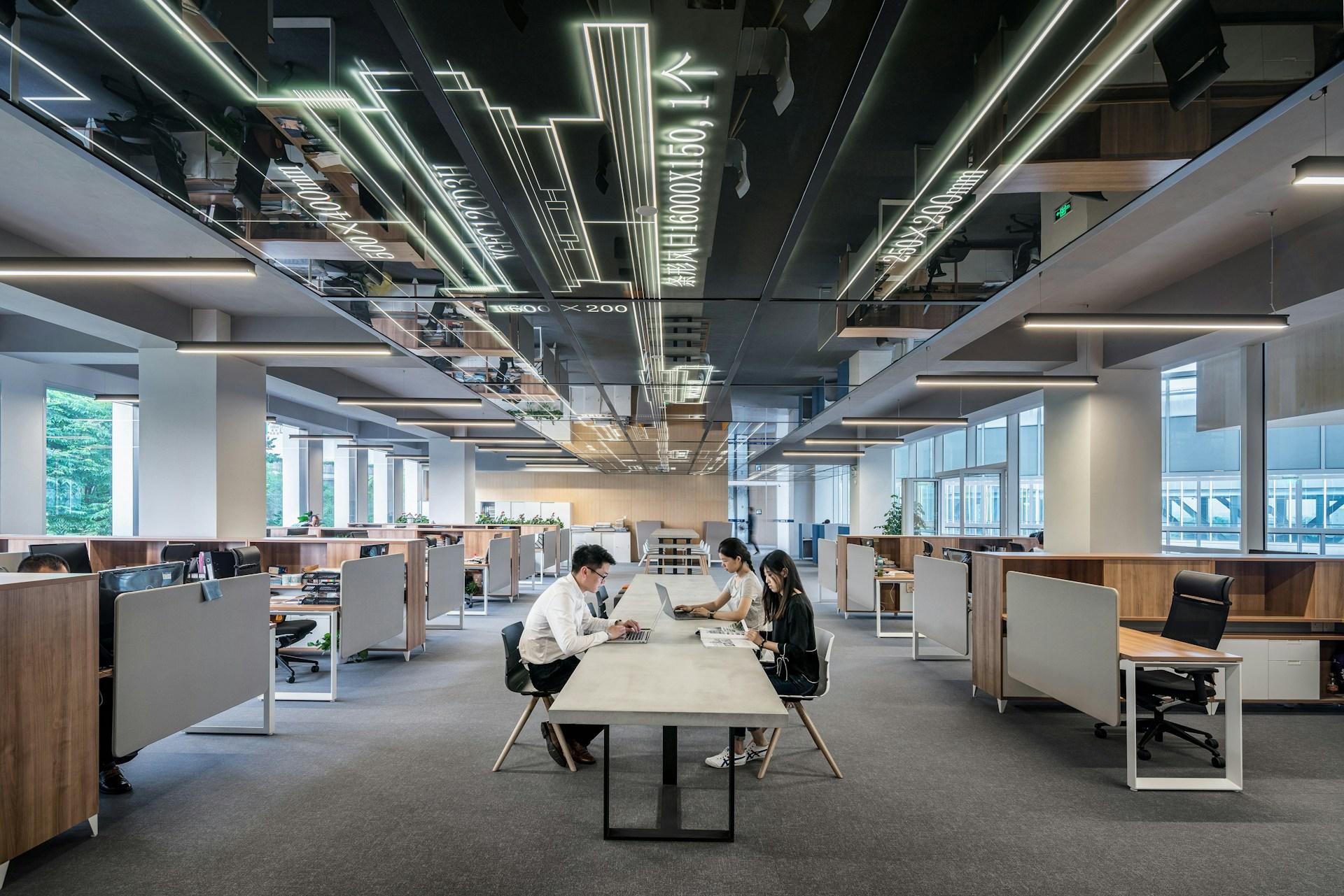 Modern office with architectural ceiling lighting and workspaces