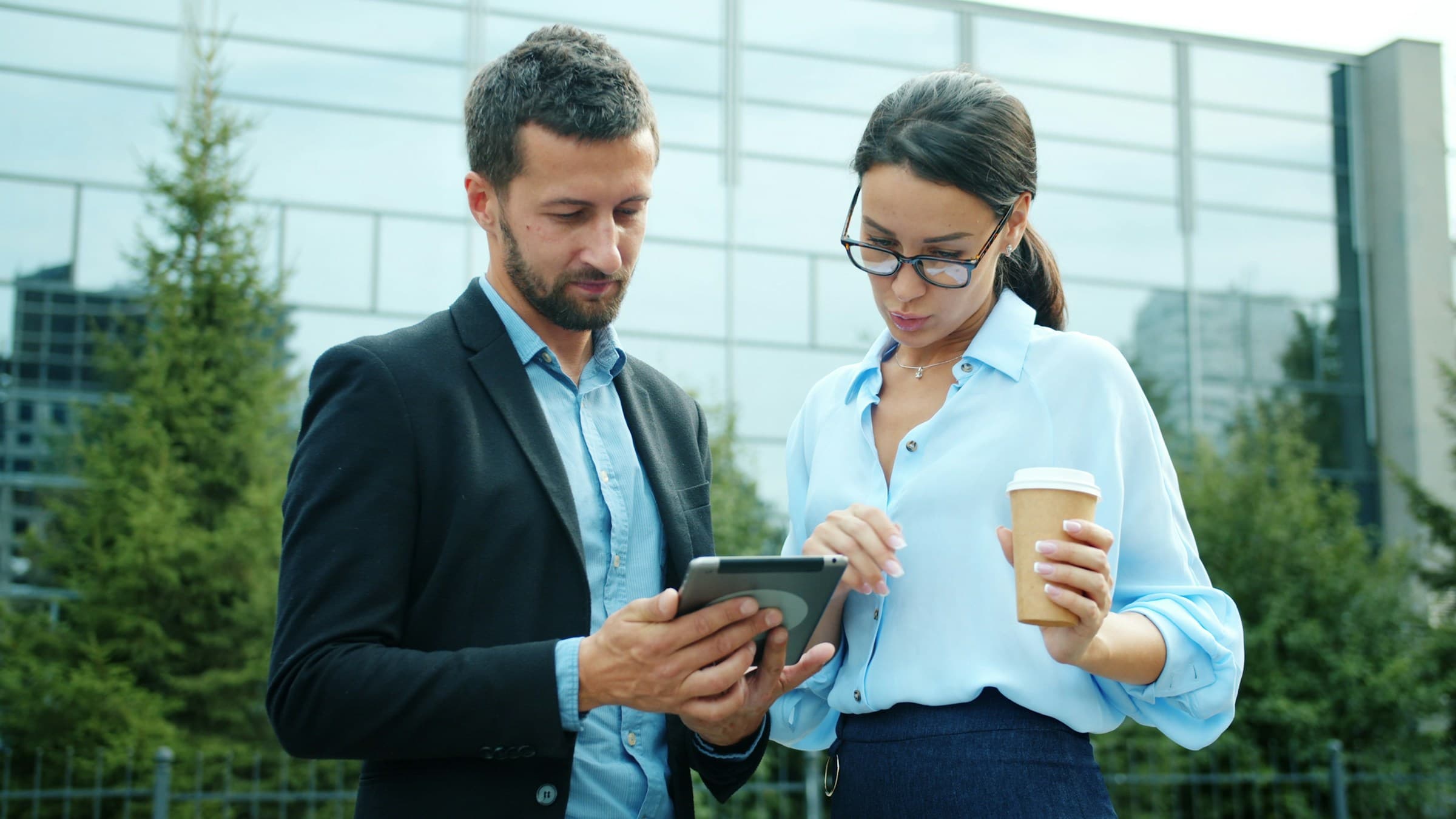 Two colleagues reviewing work together on a tablet